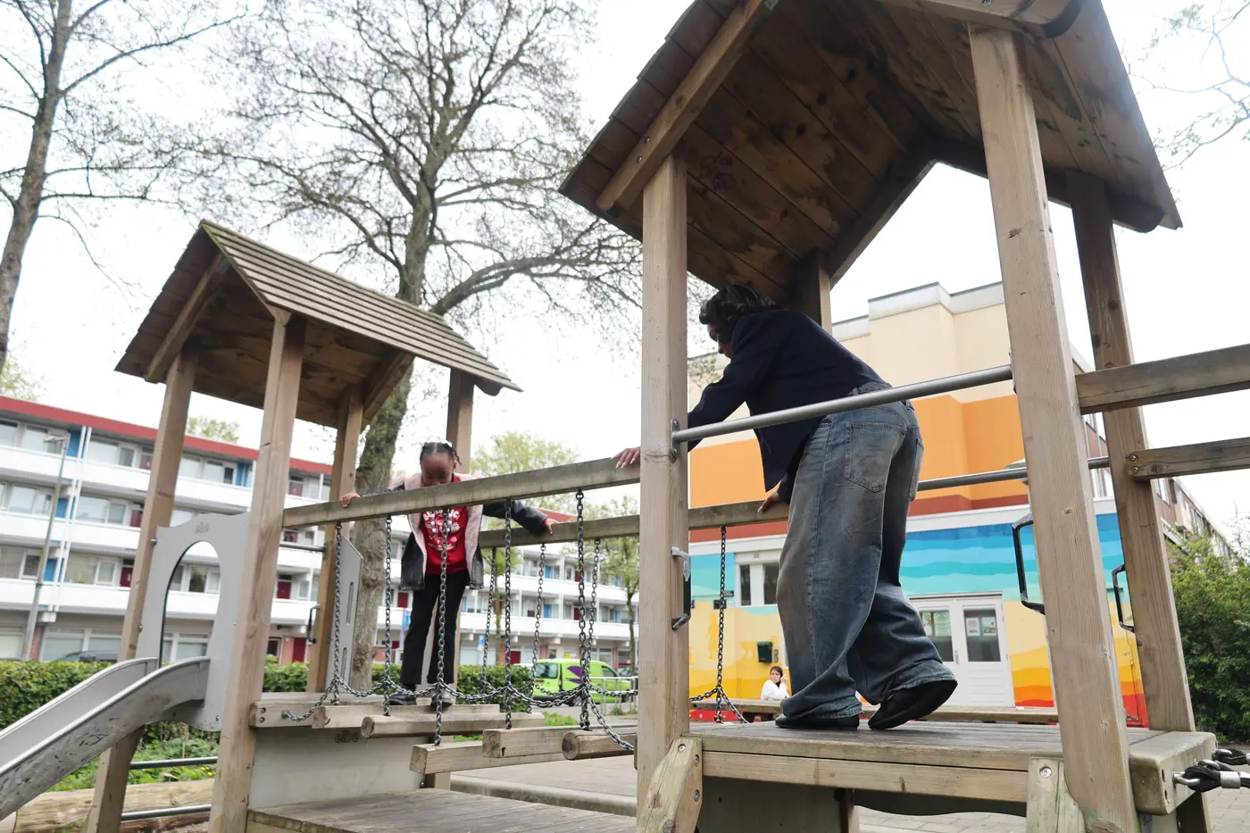 Kinderen spelen op een houten klimtoestel in een speeltuin in de buurt